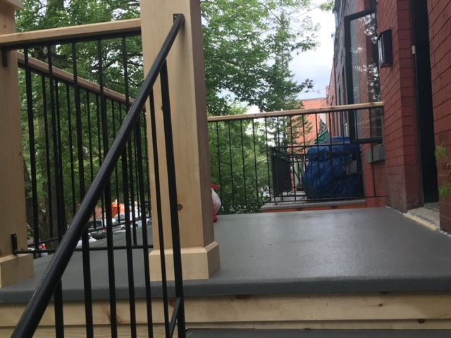 Escalier menant à un balcon avec une balustrade noire