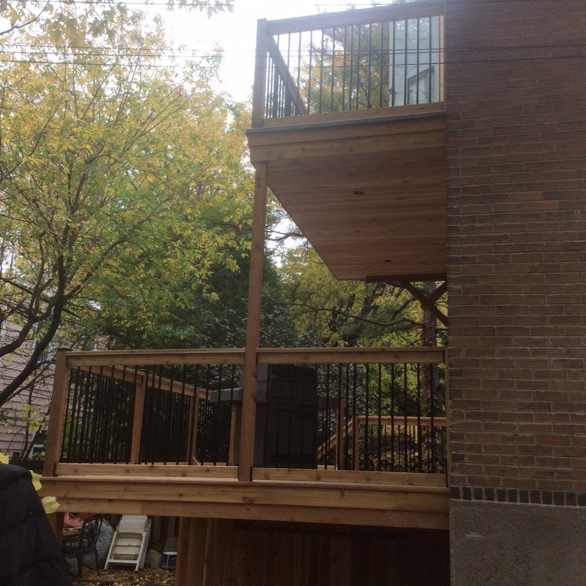 Une terrasse en bois est attachée à un bâtiment en briques