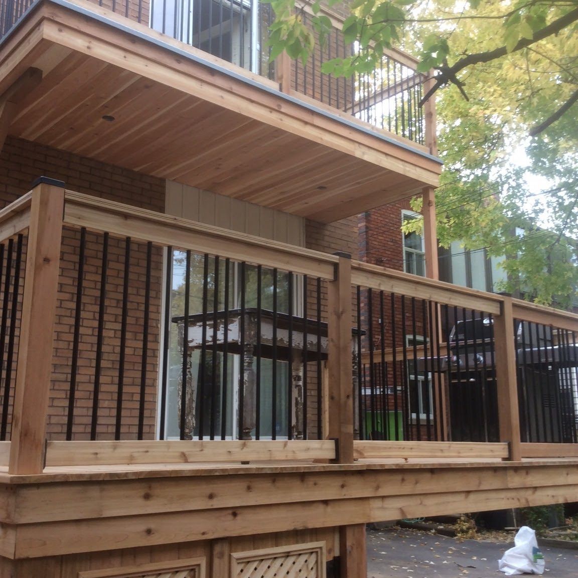 Une terrasse en bois avec un bâtiment en brique en arrière-plan