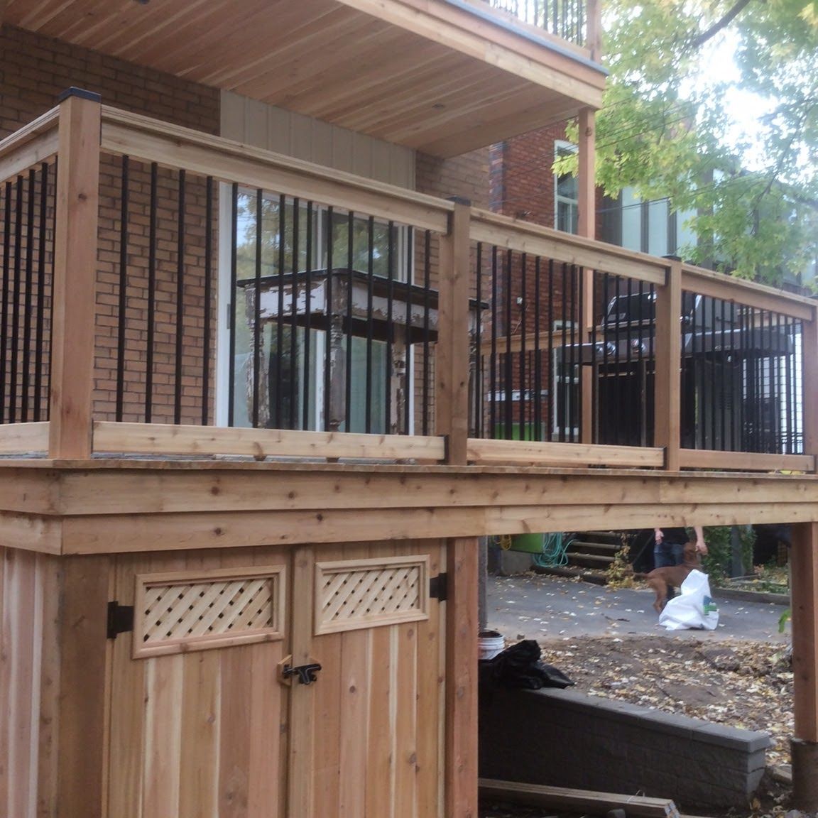 Une terrasse en bois avec une poubelle en dessous