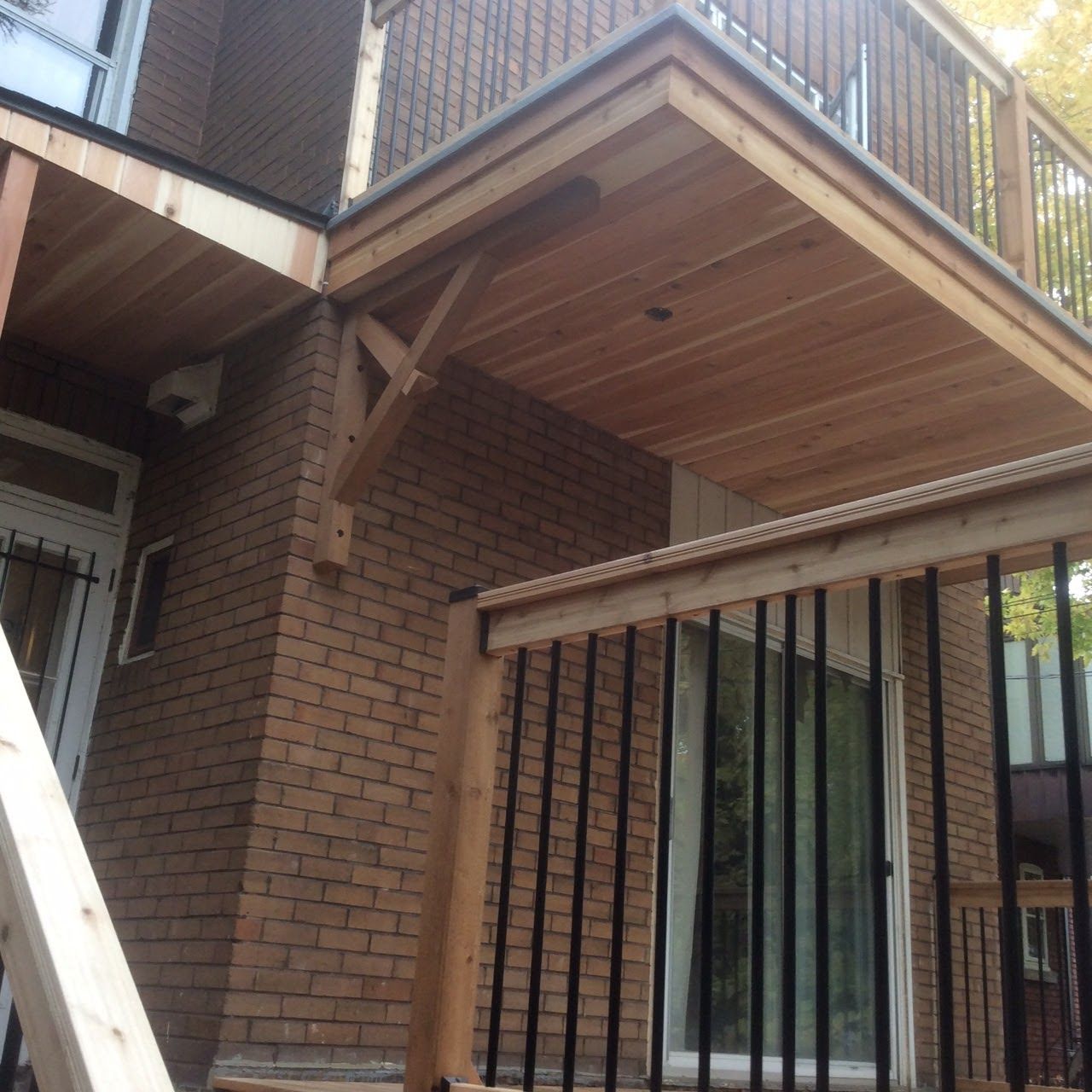 Une maison en brique avec une terrasse et des escaliers en bois