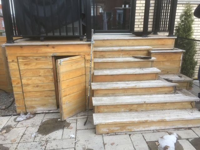 Une terrasse en bois avec des escaliers et une porte ouverte