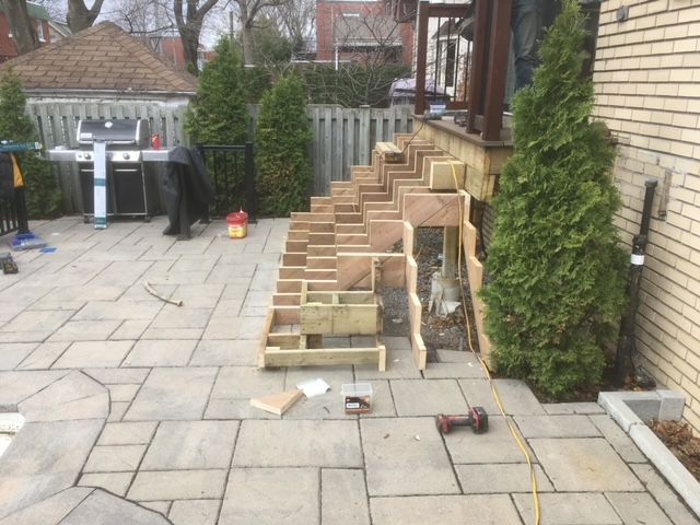 Un escalier en bois est en cours de construction sur un patio