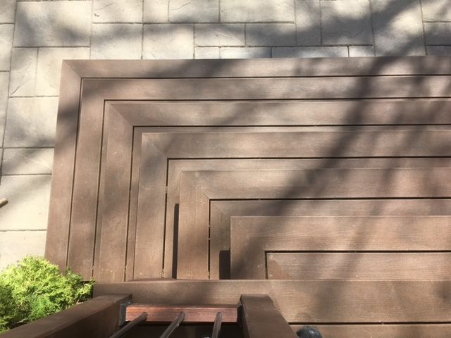 Un escalier en bois avec l'ombre d'un arbre dessus