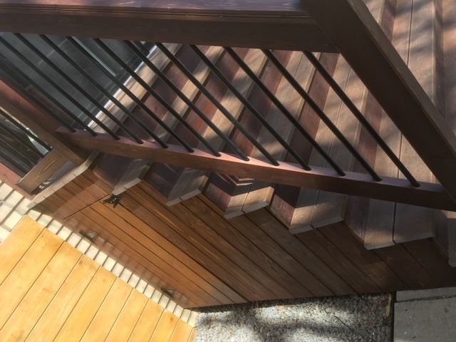 Une terrasse en bois avec des escaliers et une balustrade en métal