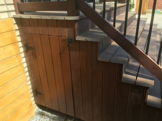 Un escalier en bois avec une armoire en bois en dessous.