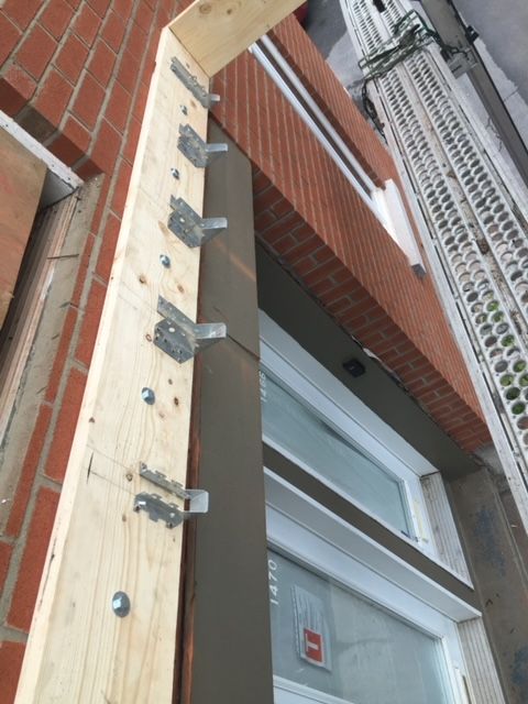 Une poutre en bois est attachée à un bâtiment en briques