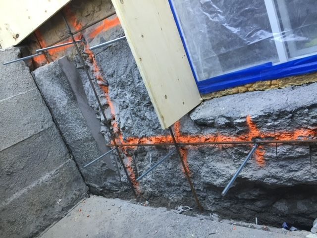 Une fenêtre est en train d'être construite dans un mur de pierre