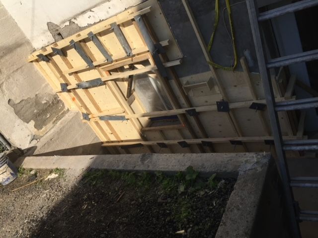 Une échelle est assise à côté d'un mur en bois