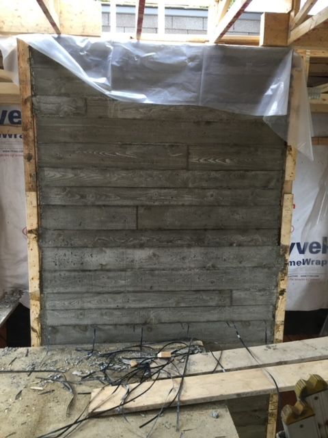 Un mur de béton est en construction dans une pièce avec un sac sur lequel est écrit verve