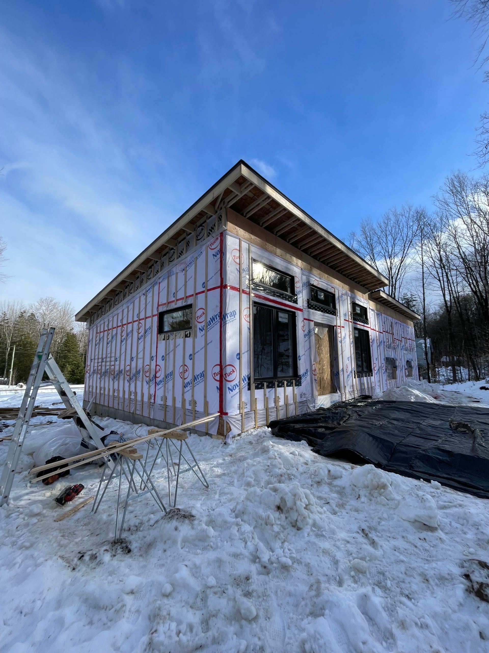 Une petite maison est en construction dans la neige.