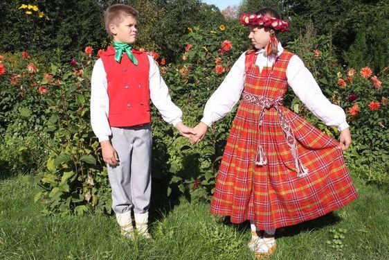 Zēns un meitene turas rokās laukā.