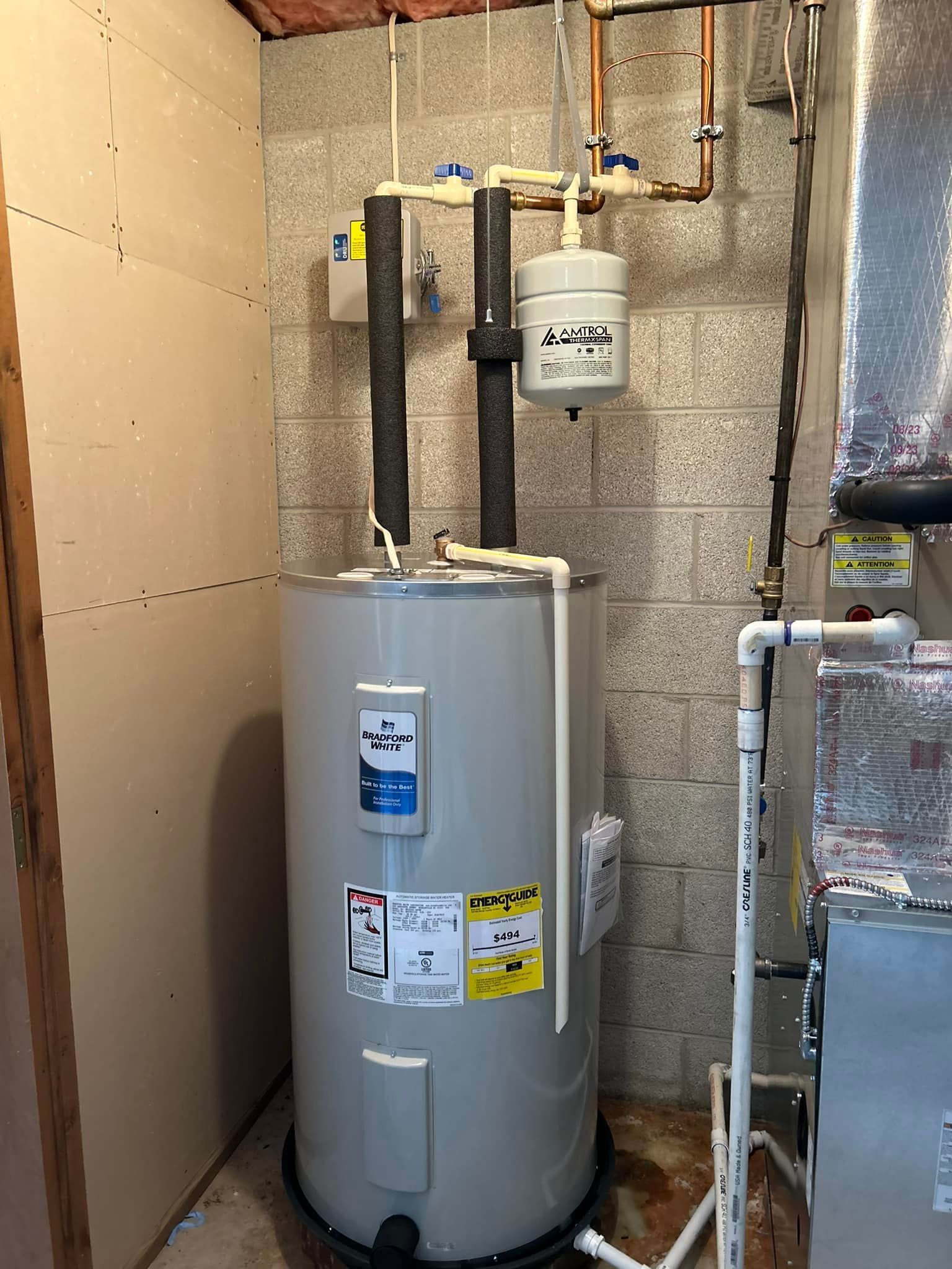 A man is fixing a water heater with a wrench.