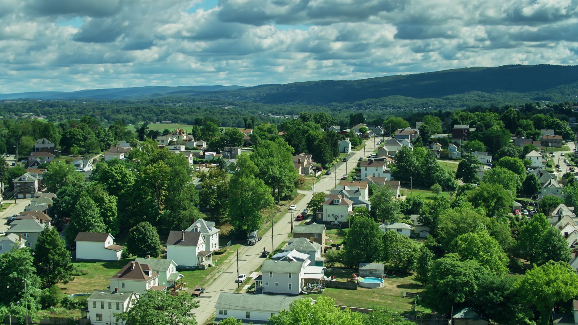 An aerial view of a small town with mountains in the background