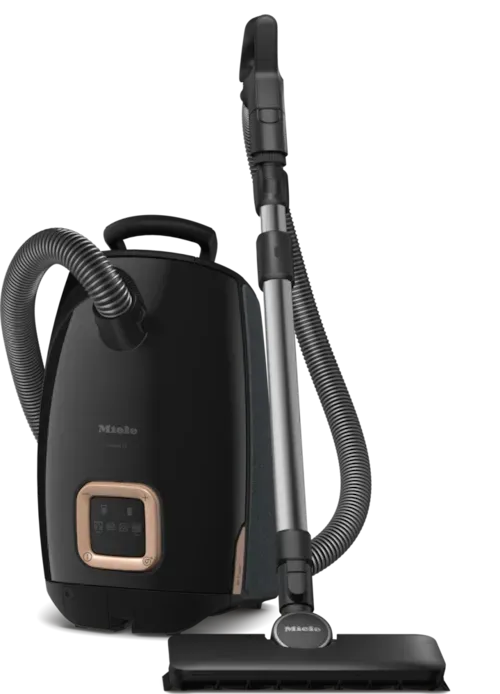 Black Miele canister vacuum cleaner with attachments, on a white background.