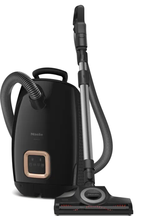 Black Miele canister vacuum cleaner with attachments, on a white background.