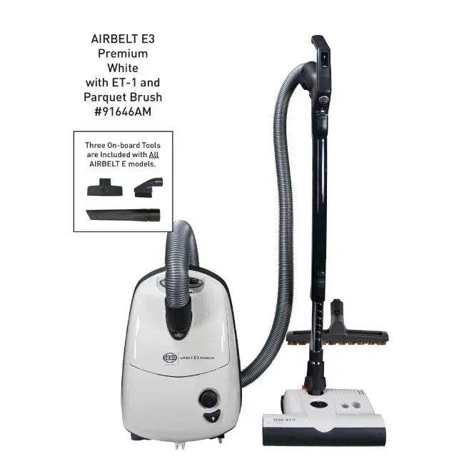 White Airbelt E3 vacuum cleaner with attached hose, brush, and on-board tools.