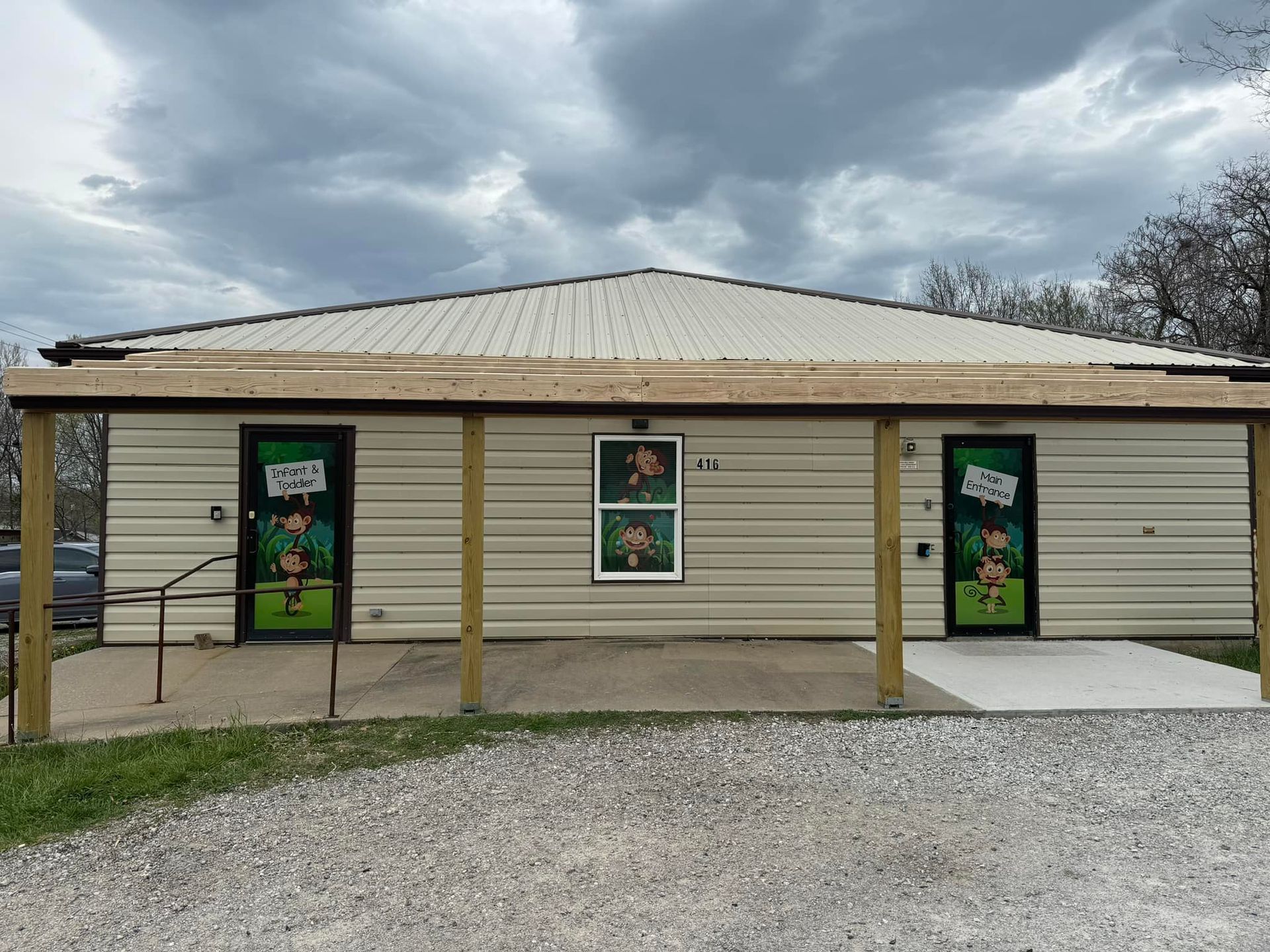 Exterior of a small building with three doors decorated with leprechaun figures, a porch, and a cloudy sky.