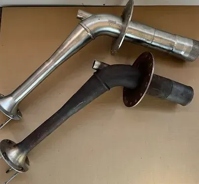 Two metal pipes are sitting on top of each other on a table.