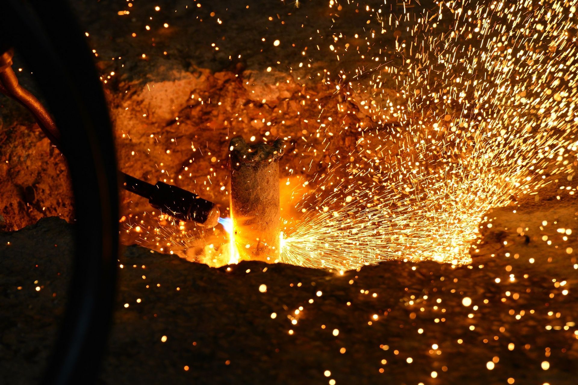 Welder cutting the steel rod using a high-temperature gas cutter.