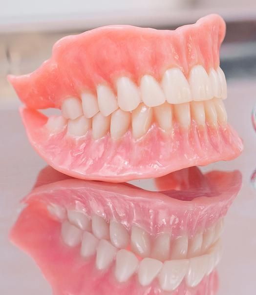 Close Up of a Denture With White Teeth on a Table — Cosmetic Denture Services–Jacob Maxwell in Moranbah, QLD