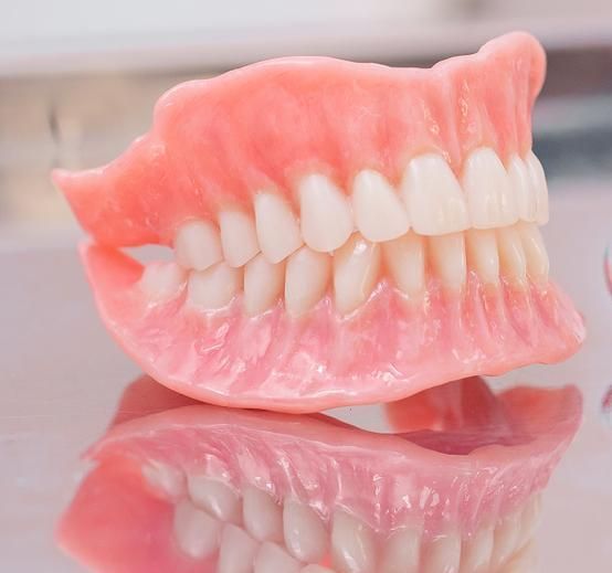 Close Up of a Denture With White Teeth on a Table — Cosmetic Denture Services–Jacob Maxwell in Moranbah, QLD