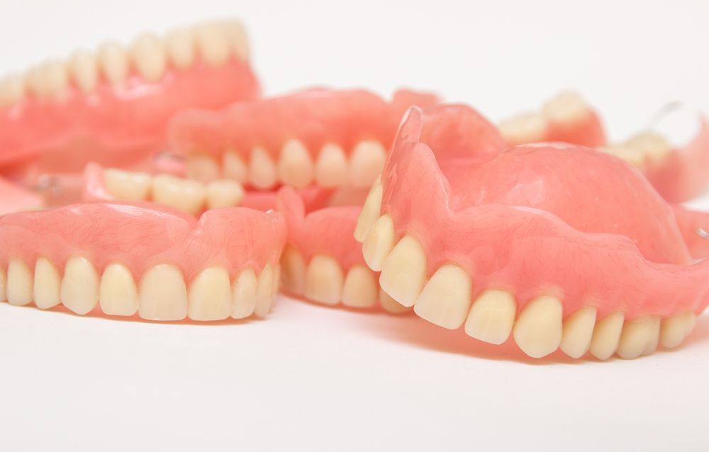 A Row of Dental Models Sitting on Top of A Table — Cosmetic Denture Services–Jacob Maxwell in Sarina, QLD