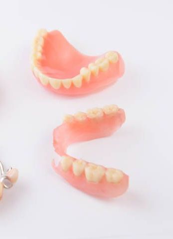 Close Up of a Pair of Dentures on a White Surface — Cosmetic Denture Services–Jacob Maxwell in Mackay, QLD
