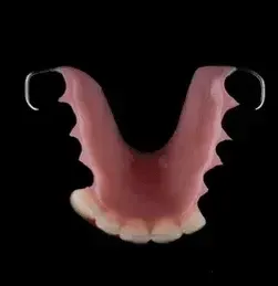 A Person Is Holding a Denture in Their Hand in Front of A Sink — Cosmetic Denture Services–Jacob Maxwell in Sarina, QLD