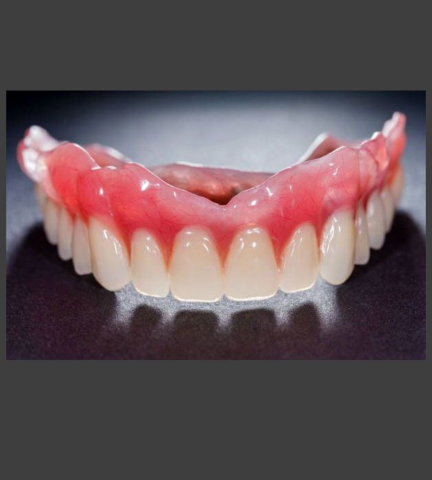 Close Up of a Denture With White Teeth and Red Gums — Cosmetic Denture Services–Jacob Maxwell in Moranbah, QLD