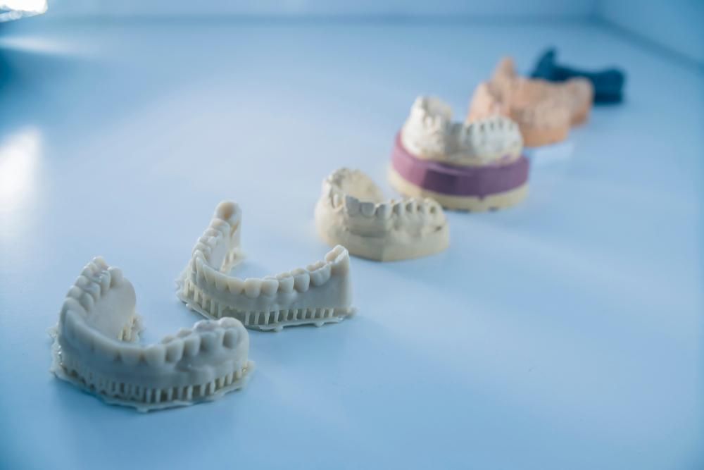 A Row of Dental Models Sitting on Top of A Table — Cosmetic Denture Services–Jacob Maxwell in Moranbah, QLD