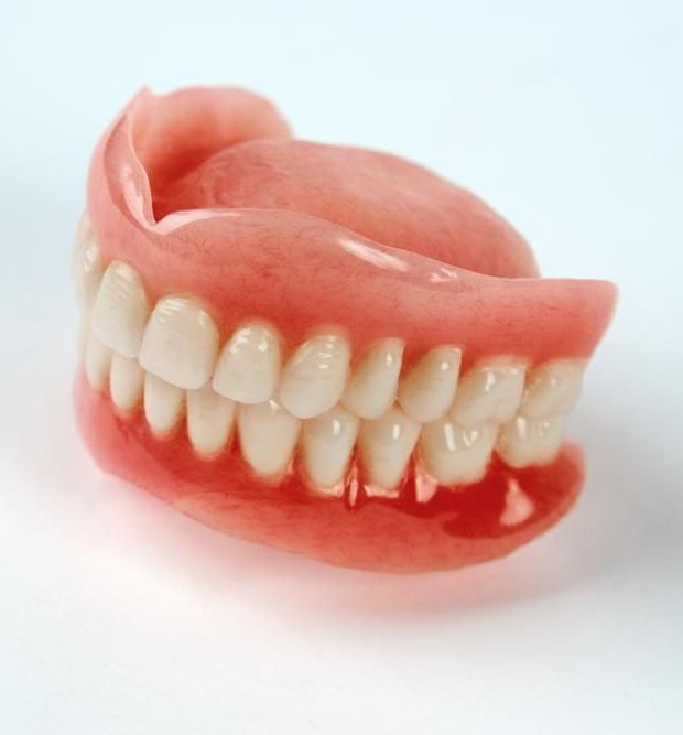 A Close up Of a Denture on A White Surface — Cosmetic Denture Services–Jacob Maxwell in Moranbah, QLD