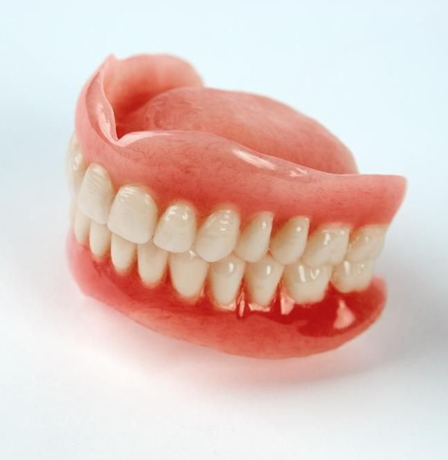 A Close up Of a Denture on A White Surface — Cosmetic Denture Services–Jacob Maxwell in Sarina, QLD