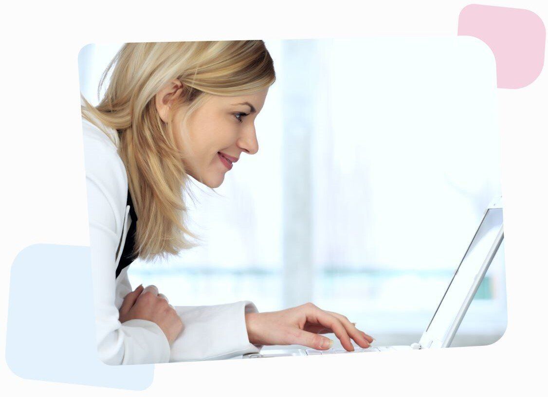 smiling woman in white browsing her laptop and reading an article