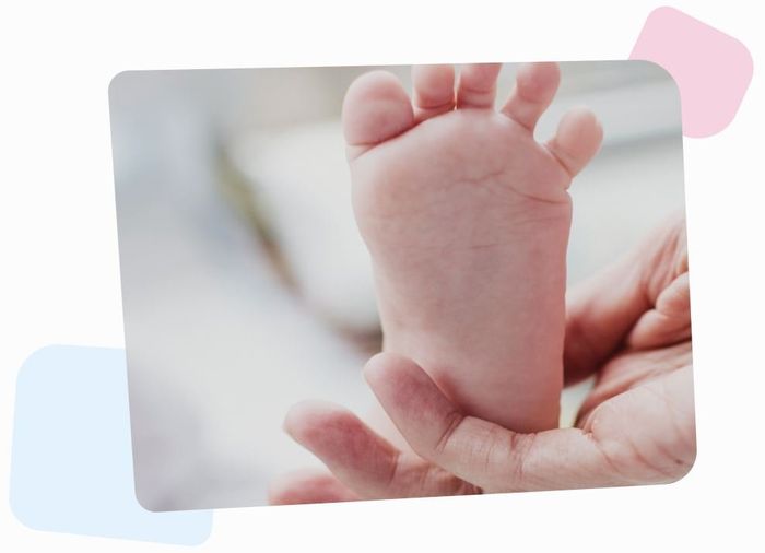 hand of a mother holding a tiny foot of her donor child