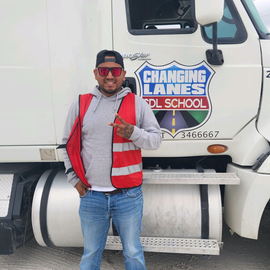 A man standing in front of a changing lanes truck