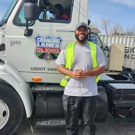 A man standing in front of a changing lanes truck