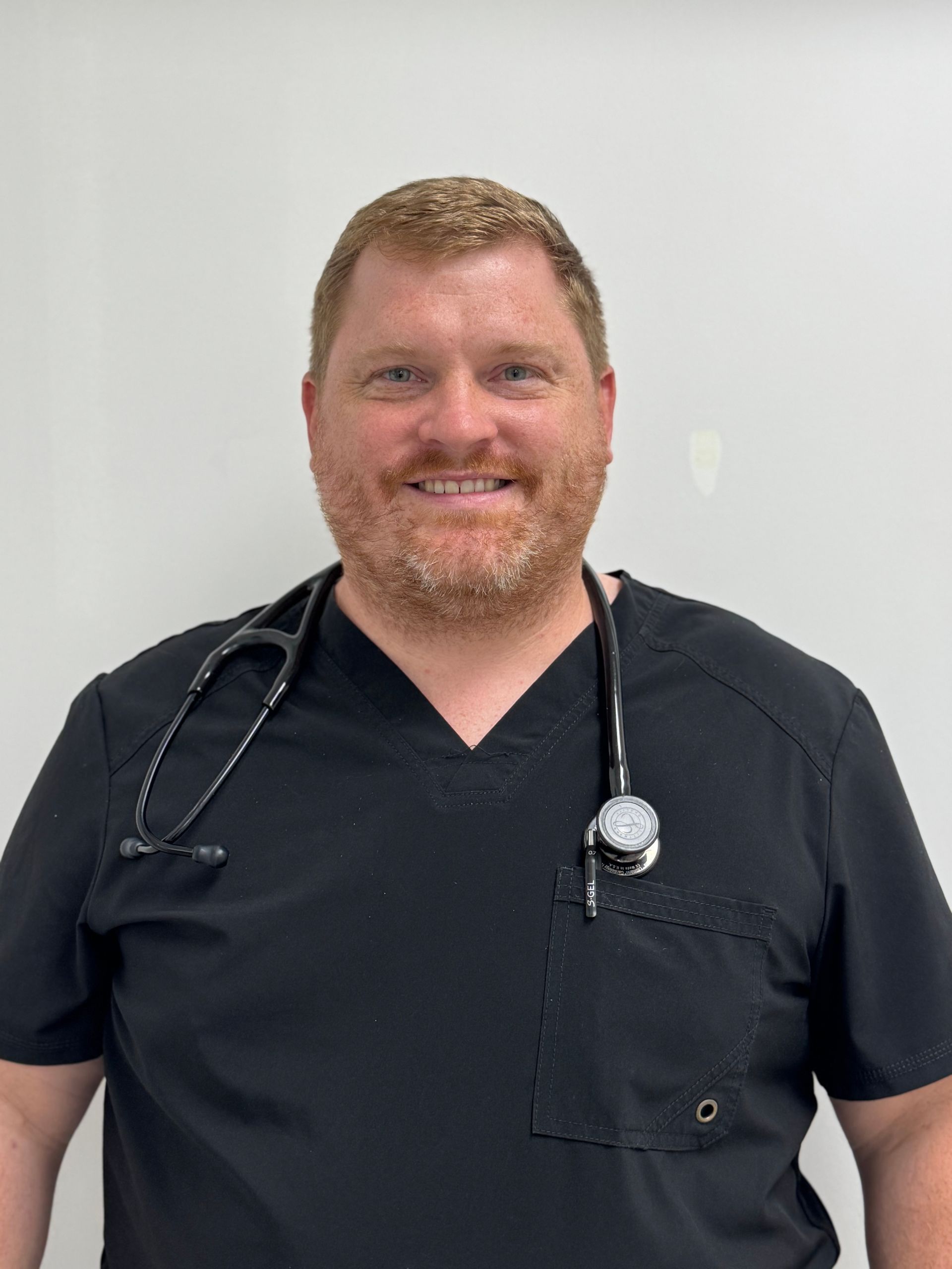A man in a graduation cap and gown is holding a diploma.