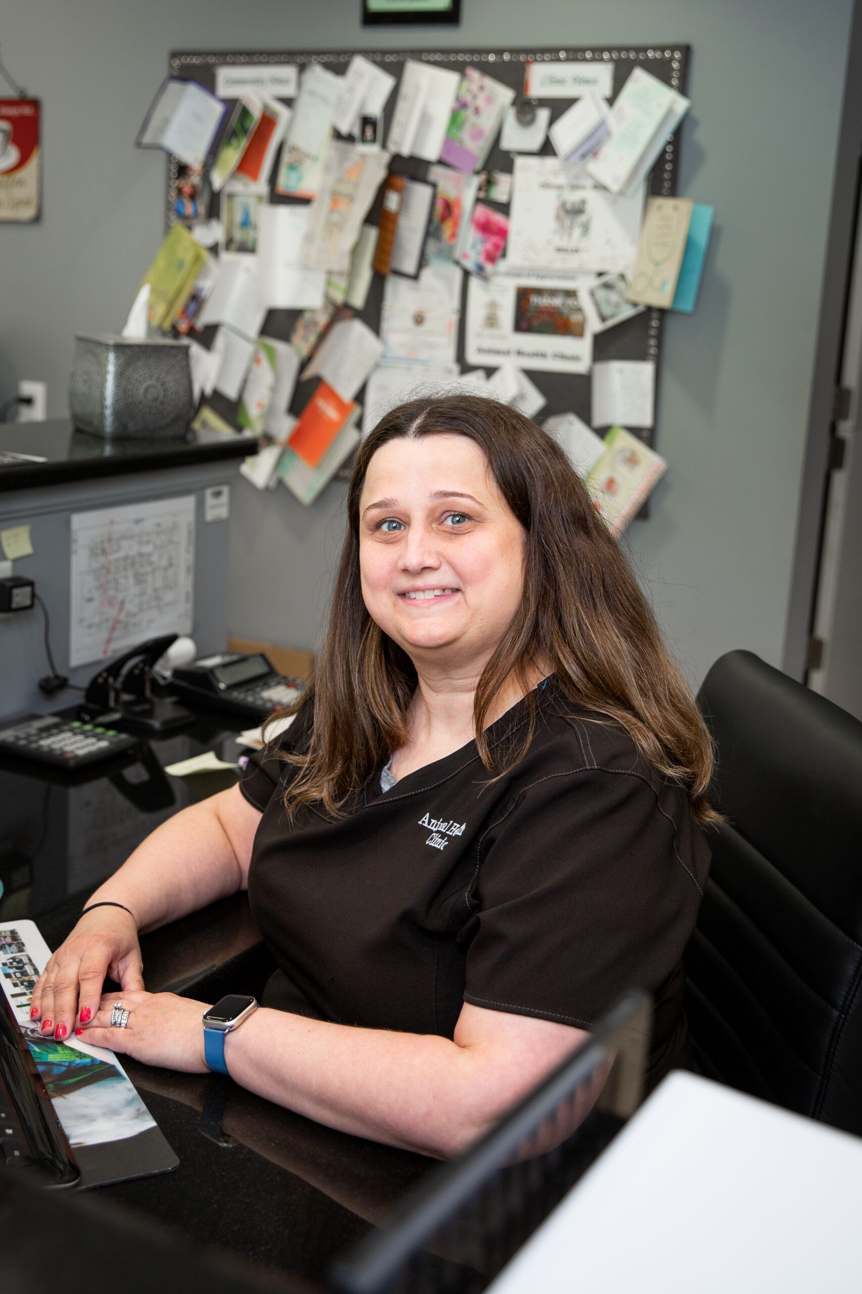 A woman is sitting at a desk in front of a computer.