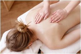 A woman is getting a massage on her back at a spa.