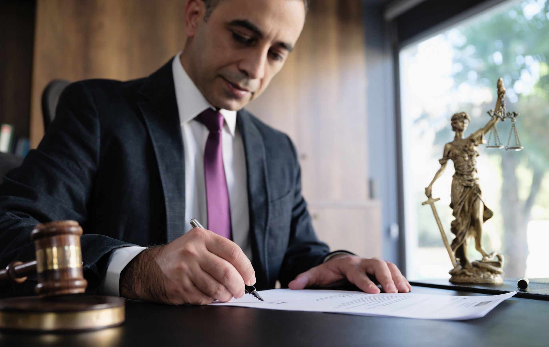 A male legal advisor lawyer examining and signing legal documents