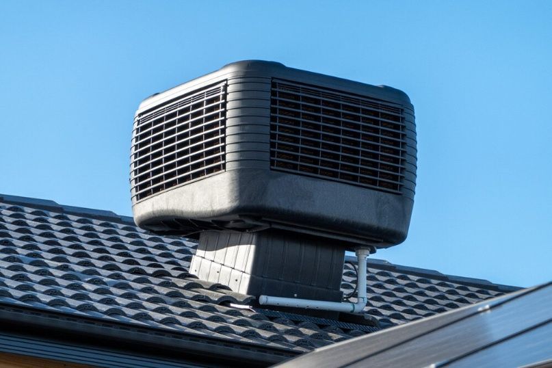 A Black Air Conditioner Is Sitting On Top Of A Roof — Cool & Secure In Maroochydore, QLD
