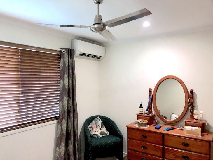 A Bedroom With A Chair A Dresser And A Mirror — Cool & Secure In Warana, QLD