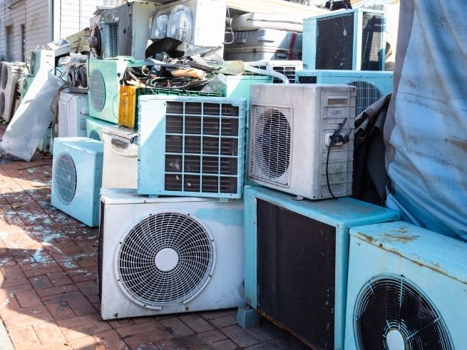 A Bunch Of Air Conditioners Are Stacked On Top Of Each Other On A Sidewalk — Cool & Secure In Buderim, QLD