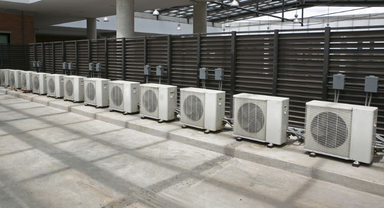 A Row Of Air Conditioners Are Lined Up In A Building — Cool & Secure In Warana, QLD