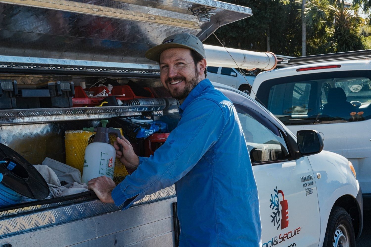 A Man Is Fixing An Air Conditioner With A Wrench — Cool & Secure In Warana, QLD