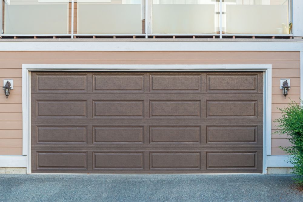 Brown Paneled Garage Door On A Beige House Exterior With White Trim — Lennox Build In Lennox Head, NSW