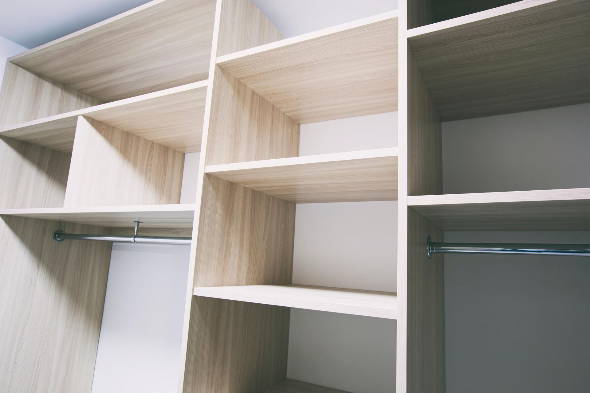 An Empty Walk in Closet With Wooden Shelves and Clothes Racks — Lennox Build In Ballina, NSW