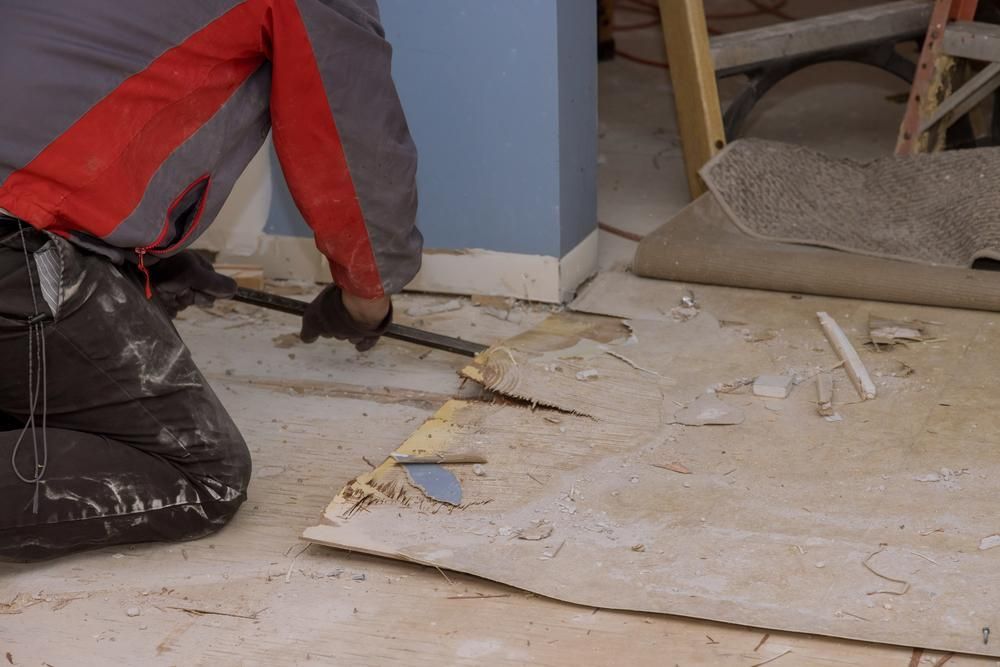 A Man is Kneeling Down on the Floor Using a Shovel — Lennox Build In Brunswick Head, NSW