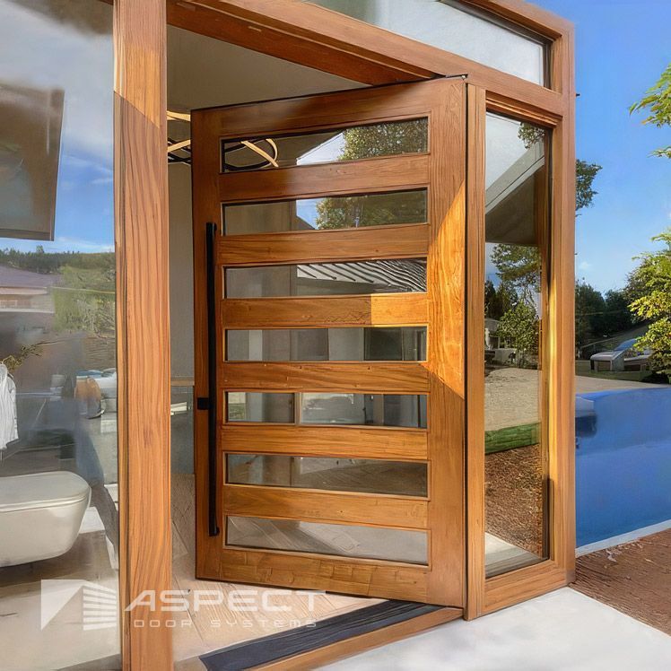 Wooden pivot door with multiple glass panels, open in a modern home entrance — Lennox Build In Lennox Head, NSW